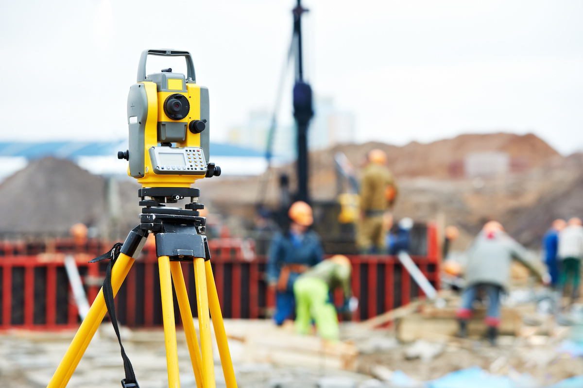 Surveying measuring equipment theodolite transit on tripod at construction building area site